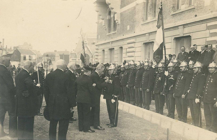 Charles Conem décorant d'une médaille un sapeur-pompier [M. Lys] devant l'hôtel de ville