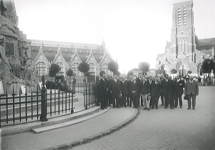 Groupe d'hommes posant à côté du monument aux morts