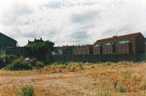 Terrain en friche après le comblement de la Lys au niveau du pont National et vue sur le foyer-logement résidence des Prés du Hem