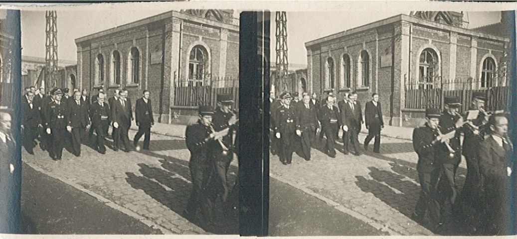 Georges Vankemmel et Gustave Duriez défilant dans la rue Jean Jaurès près de l'usine à gaz, entourés de musiciens et personnalités