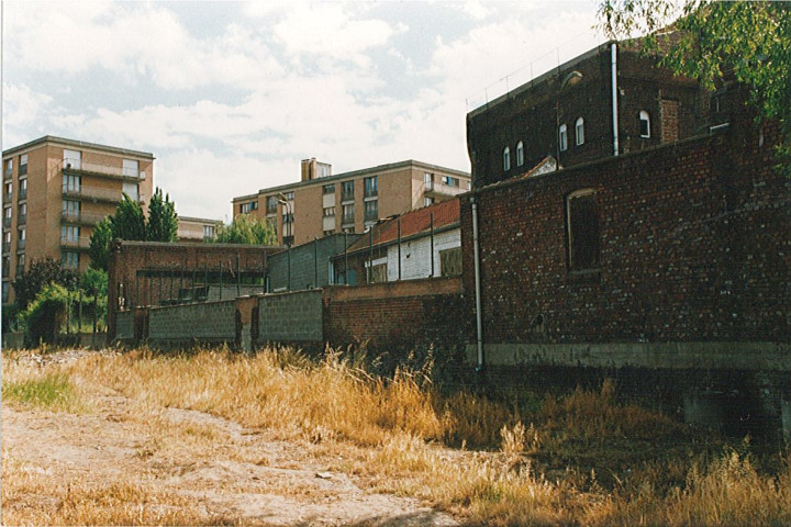 Terrain en friche après le comblement de la Lys au centre-ville et vue sur les résidences de la Lys