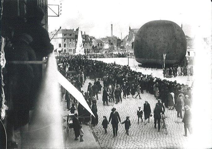 Foule observant l'envol d'un ballon dirigeable (montgolfière) sur la Grand'Place