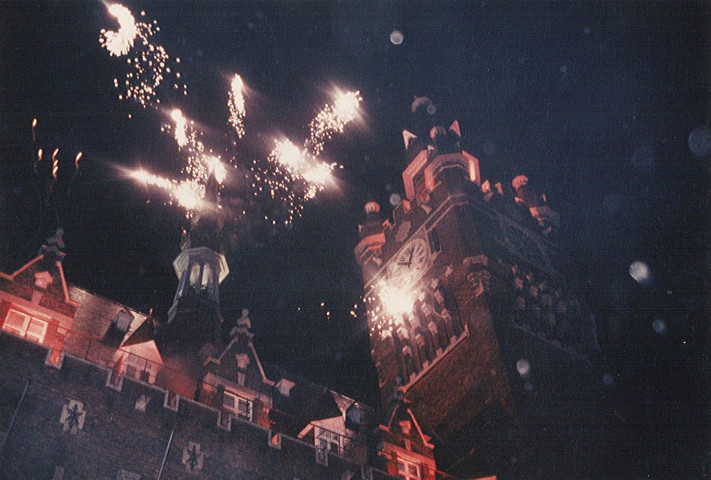 Feu d'artifice à l'arrière de l'hôtel de ville lors de [la fête des Nieulles ou de la célébration du cinquantenaire du beffroi]