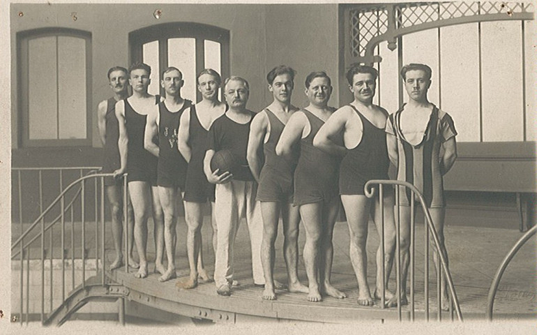 Équipe de water polo posant au bord du bassin de la piscine municipale