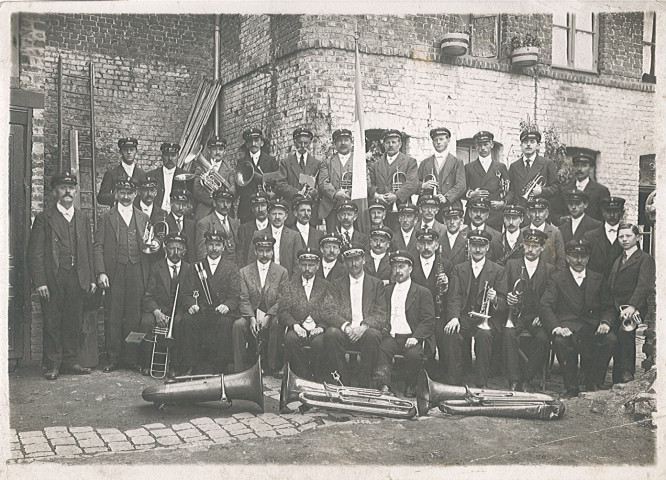 Groupe de musiciens posant dans la cour d'un bâtiment endommagé