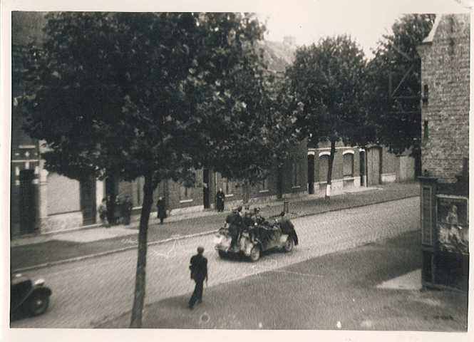 Résistants des Forces Françaises de l'Intérieur (FFI) à bord d'un véhicule militaire rue du faubourg de Dunkerque