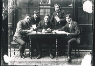 Jeunes hommes réunions autour d'une table dans un café avec l'enseigne Motte-Cordonnier