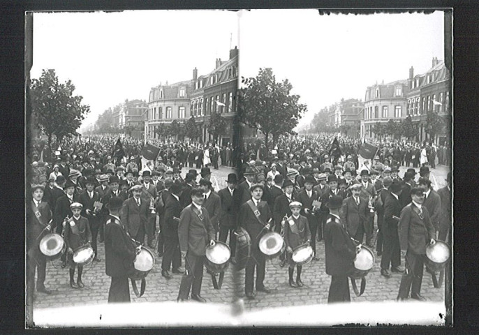 Foule et musiciens attendant les participants d'un concours de pêche à la sortie de la gare