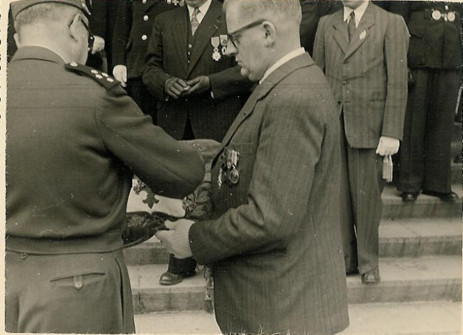 Croix de guerre apposée sur le coussin aux armoiries de la ville par le général Koenig