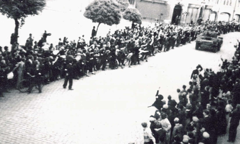 Défilé de blindé anglais longeant la foule sur la Grand'Place
