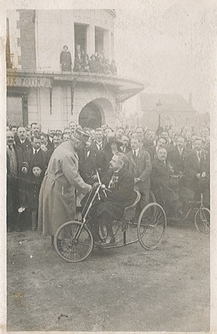 Visite officielle du maréchal Foch pour la remise de la croix de guerre à la ville, pose avec [un vétéran de guerre] en fauteuil roulant